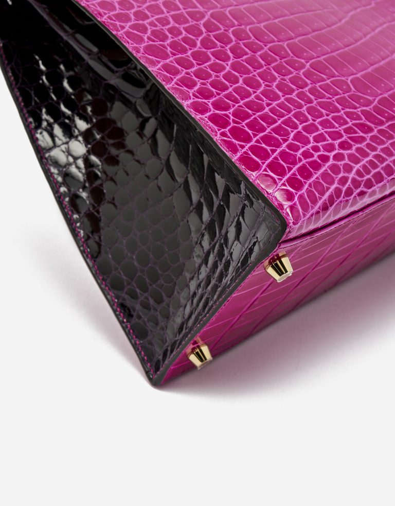 Gold-plated metal feet of a pre-loved Hermès Kelly 35 HSS Crocodile Porosus Rose Scheherazade / Aubergine on SACLÀB