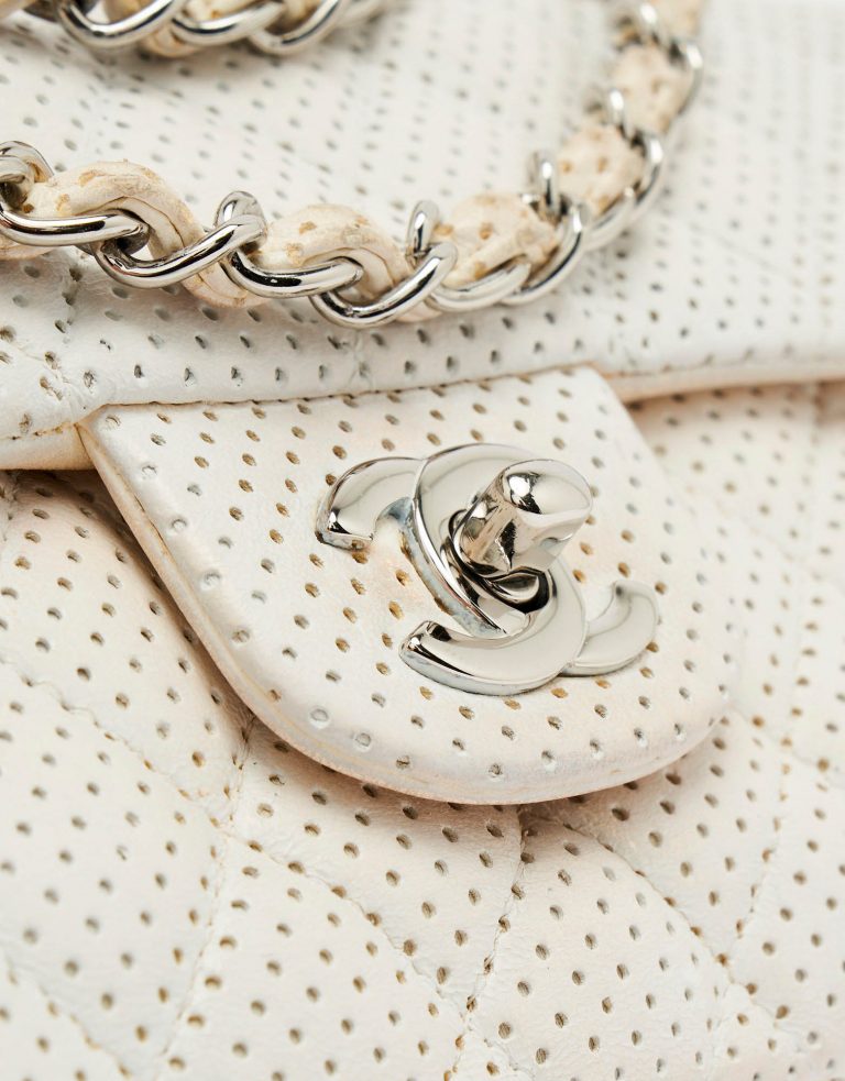 Silver turn-lock detail of a pre-loved Chanel Timeless Baguette Lamb Off White on SACLÀB