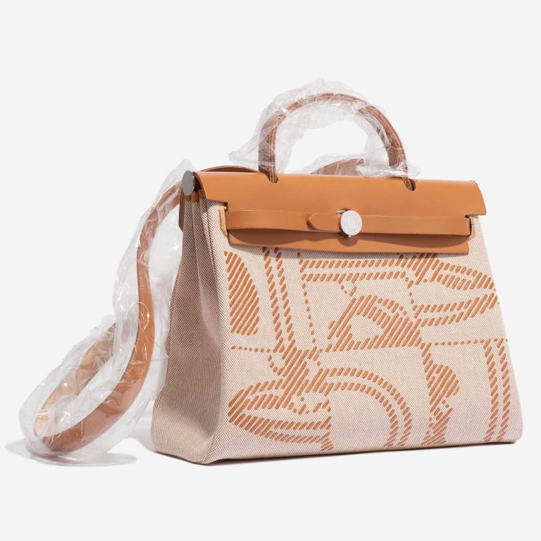 Pre-owned Hermès bag Herbag Zip 31 Toile / Vache Hunter Natural / Sable / Écru / Beige Beige, Brown Side Front | Sell your designer bag on Saclab.com
