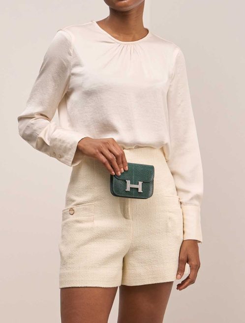 Hermès Constance Slim Wallet Niloticus Lizard Vert Cyprès on Model | Sell your designer bag
