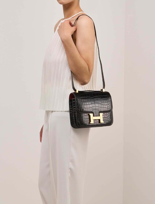 Hermès Constance 24 Alligator Mississippi Black / Rouge Grenat on Model | Sell your designer bag
